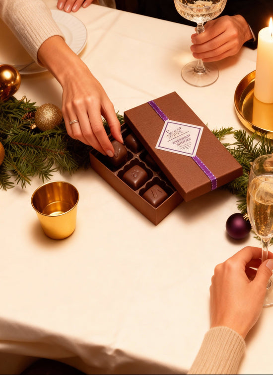 People at a festive table with chocolates and champagne.